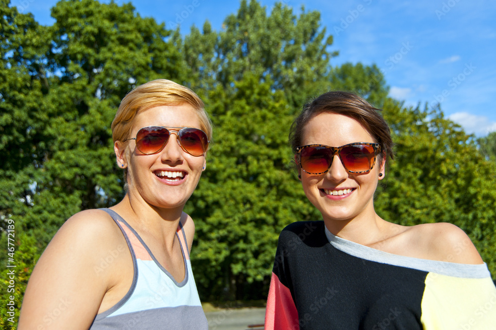 Two beautiful woman with sunglasses on natural background Two beautiful woman with sunglasses on natural background