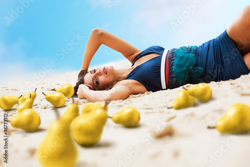 woman with yellow pears on the sand