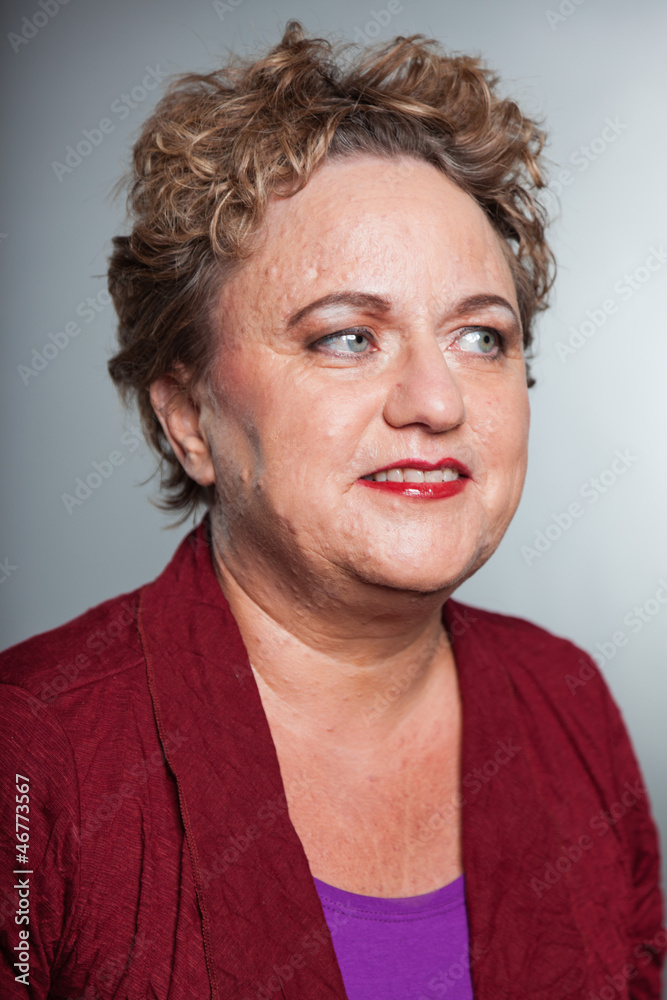 Smiling senior woman with short curly hair. Studio shot. Smiling senior woman with short curly hair. Studio shot.