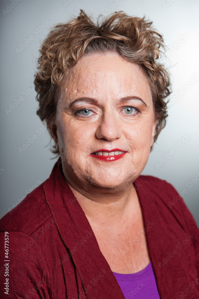 Smiling senior woman with short curly hair. Studio shot. Smiling senior woman with short curly hair. Studio shot.