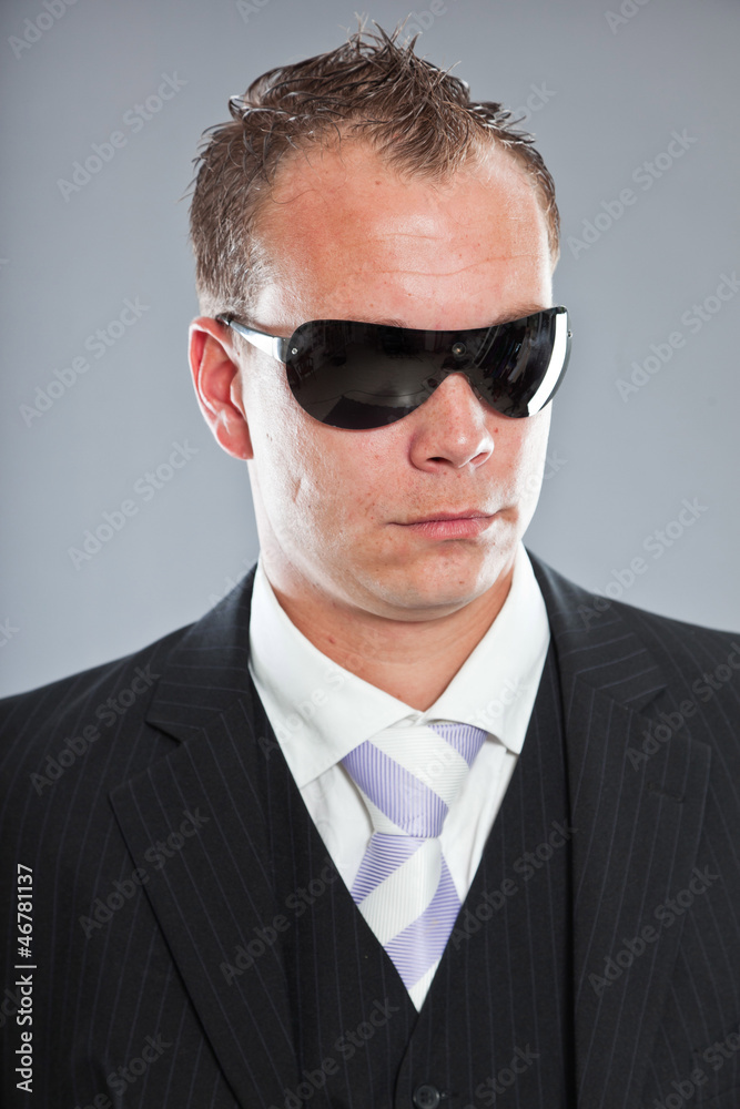 Macho business man with short hair wearing black sunglasses. Macho business man with short hair wearing black sunglasses.