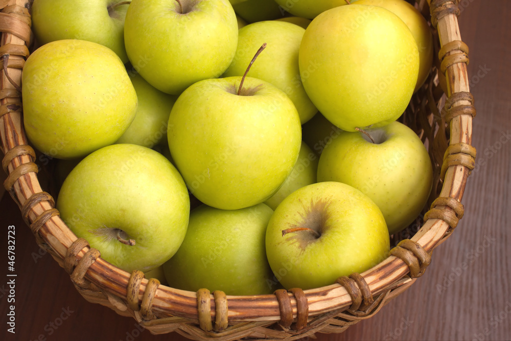 Many ripe apples in brown wicker basket closeup Many ripe apples in brown wicker basket closeup