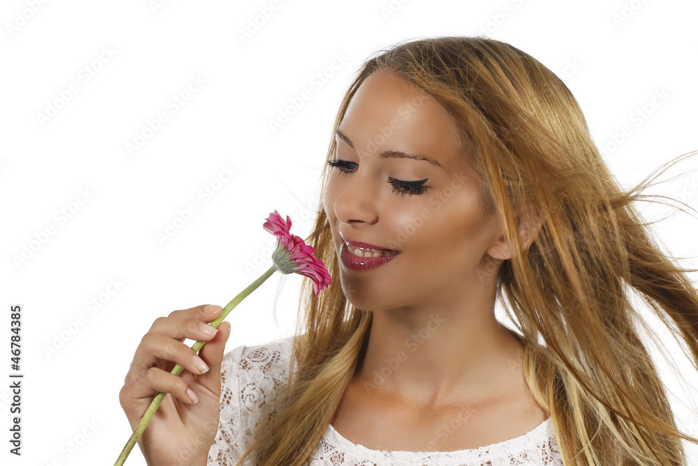 Fototapeta premium Hübsche junge Frau schnuppert an rosa Blüte