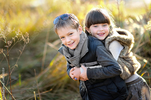 portrait of little boy and girl outdoors in autumn photo