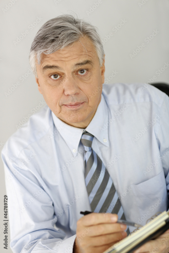 Portrait of senior businessman looking at agenda Portrait of senior businessman looking at agenda