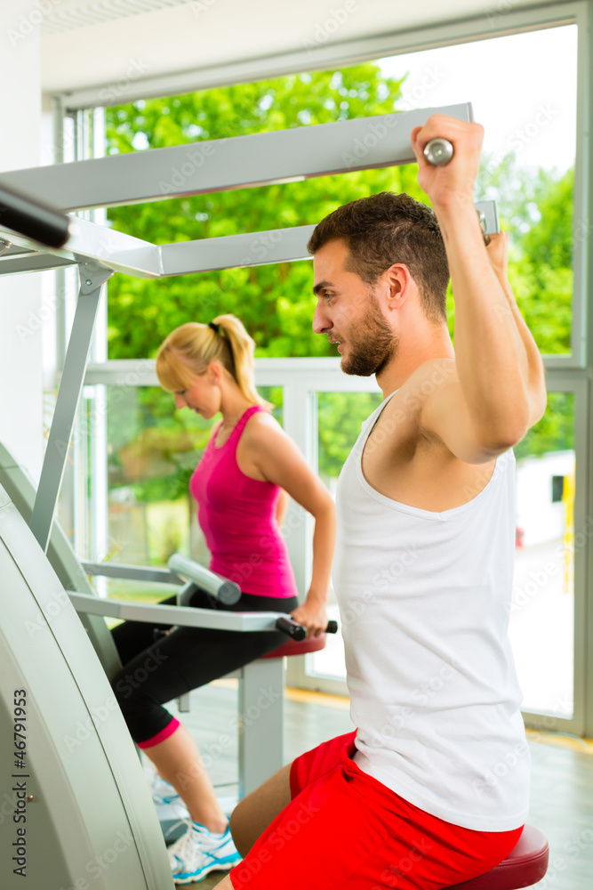 Fitnessstudio - Leute beim Sport am Gerät Fitnessstudio - Leute beim Sport am Gerät