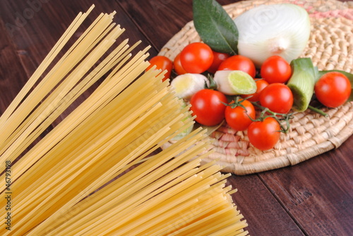 spaghetti and tomatoes on a wooden table