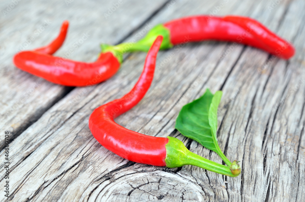 Red hot chili peppers over old wooden background Red hot chili peppers over old wooden background