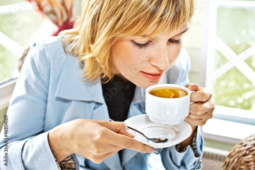 women drinking coffee in café smiling