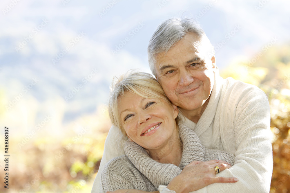 Senior couple embracing each other in countryside - obrazy, fototapety, plakaty 