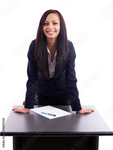 Beautiful businesswoman standing with hands on desk isolated on