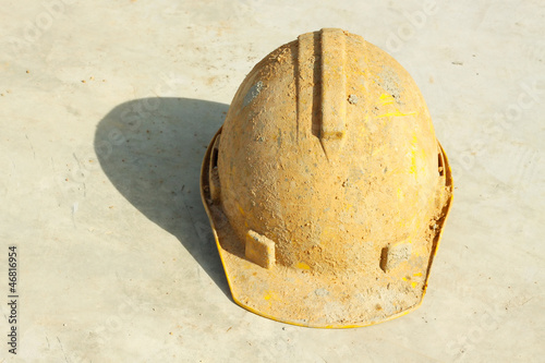 Dirty yellow hard hat on white background.