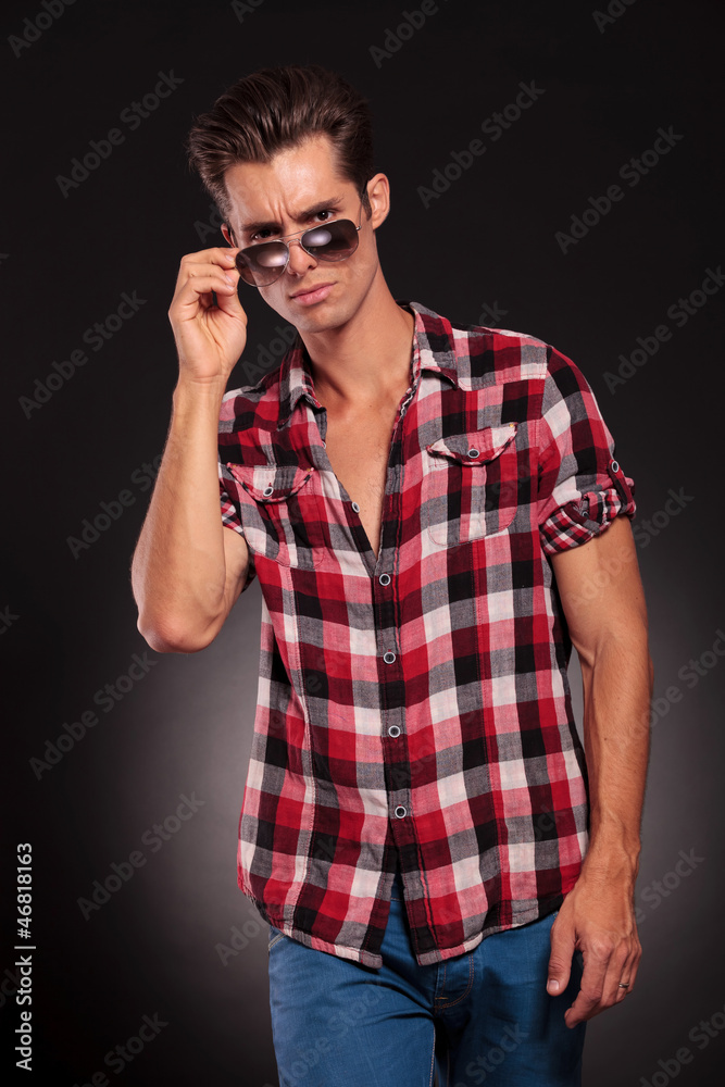 Fashion young man holding his fashionable sunglasses