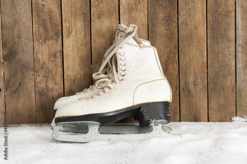 ice skates against an weathered wooden wall