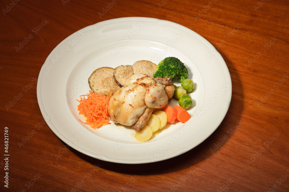 Dinner of vegetables and chicken on a plate and wooden table. Dinner of vegetables and chicken on a plate and wooden table.