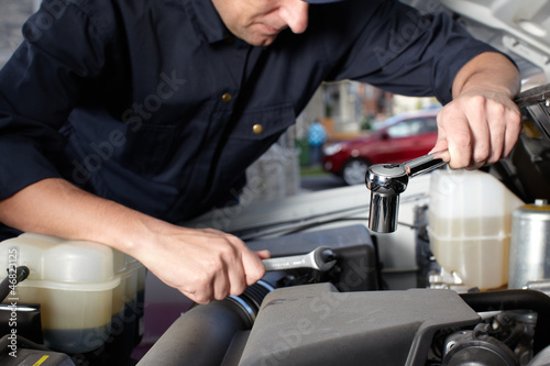 Car mechanic working in auto repair service.