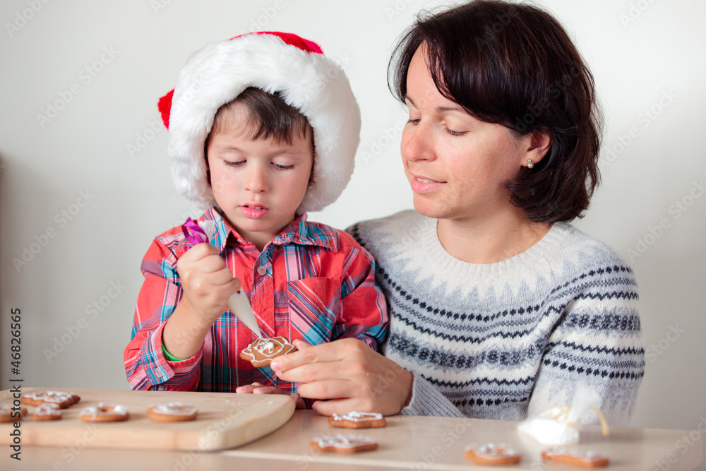 Fototapeta premium Mother and son decorating the gingerbread cookies