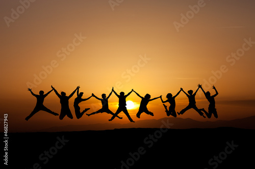 silhouette of teens jumping in sunset