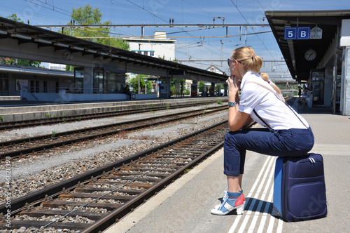 Girl with a suitcase at the train station