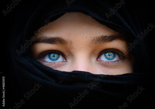 Beautiful blue woman eyes behind black scarf looking up