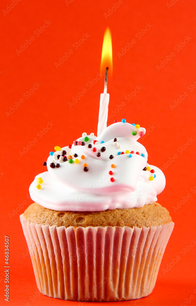 tasty birthday cupcake with candle, on red background tasty birthday cupcake with candle, on red background