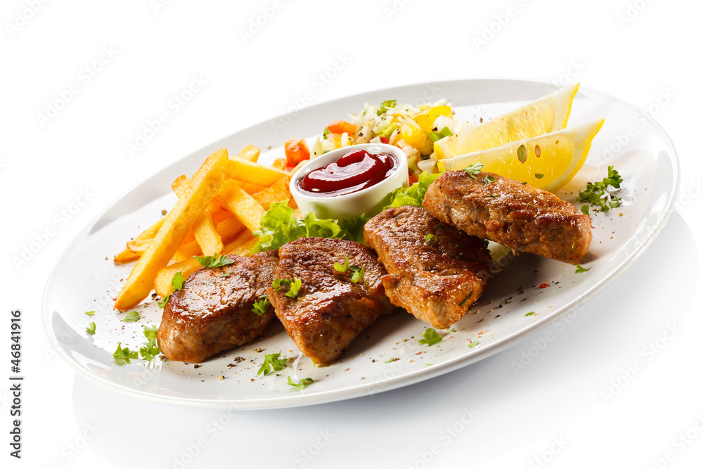 Grilled steaks, French fries and vegetables