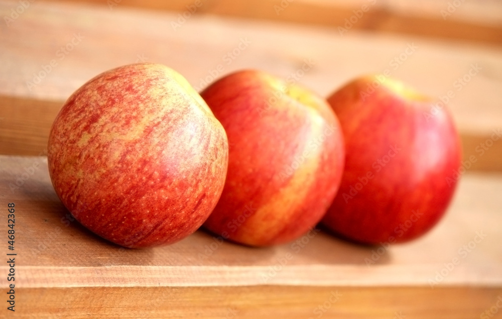 Three fresh red apples on the board Three fresh red apples on the board