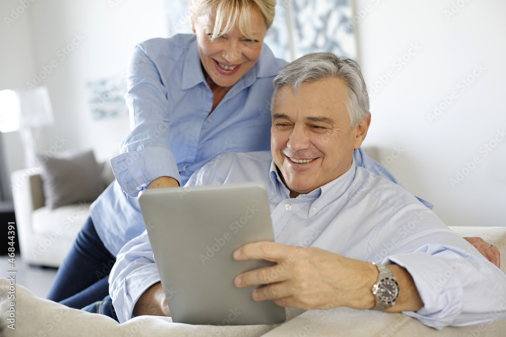 Modern senior couple websurfing on tablet