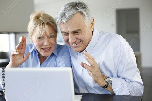 Senior couple connected with family on internet photo