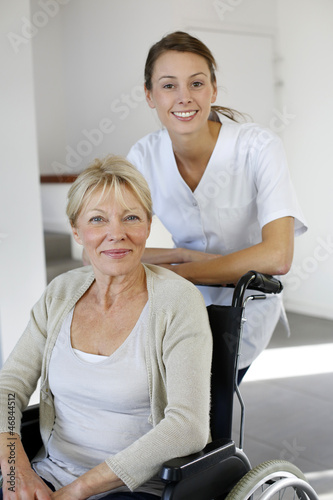 Nurse at home with elderly person in wheelchair