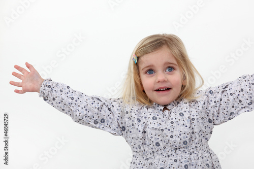 A little girl with stretched arms.