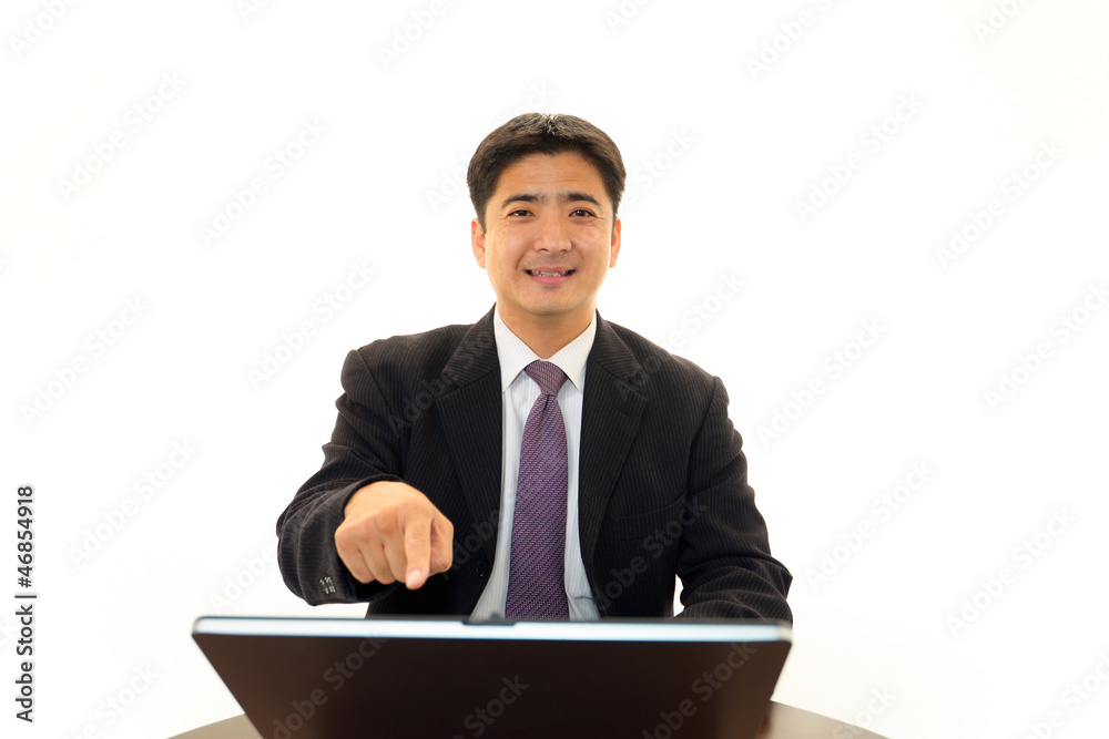 ノートパソコンで仕事中の笑顔のビジネスマン