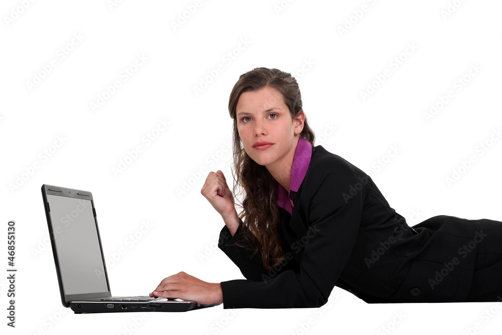 Businesswoman lying on the floor with her laptop Businesswoman lying on the floor with her laptop