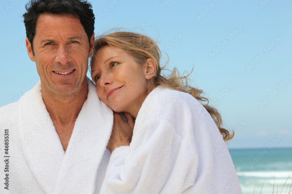 couple in bathrobes on the beach couple in bathrobes on the beach