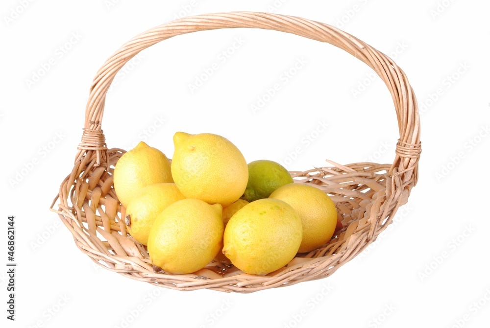 organic lemons in a straw basket, isolated on white