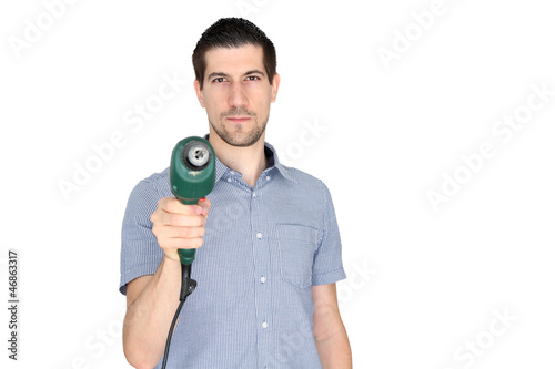 Attractive young man holding an electric drill