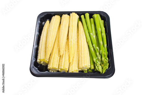 Asparagus and baby corn in black container isolated on white bac