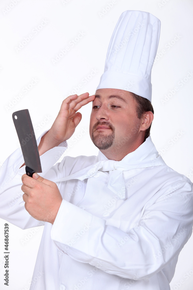 Professional chef checking his image in a knife Professional chef checking his image in a knife