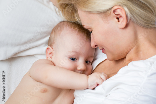 happy mother lying with baby boy