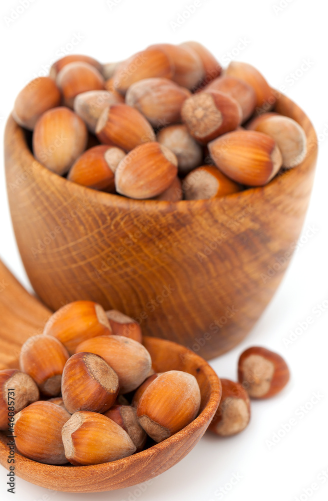 hazelnuts in a wooden spoon and bowl hazelnuts in a wooden spoon and bowl