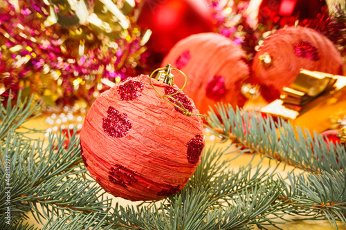 Red decoration ball with spruce branch on blurred  Christmas bac