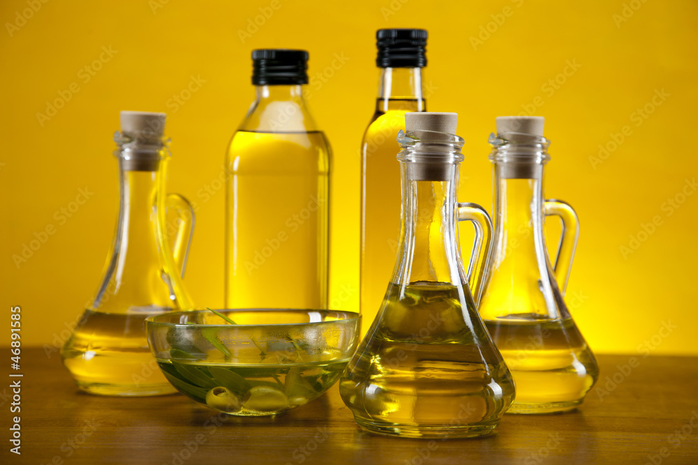 Olive oil and olives set on yellow background Olive oil and olives set on yellow background