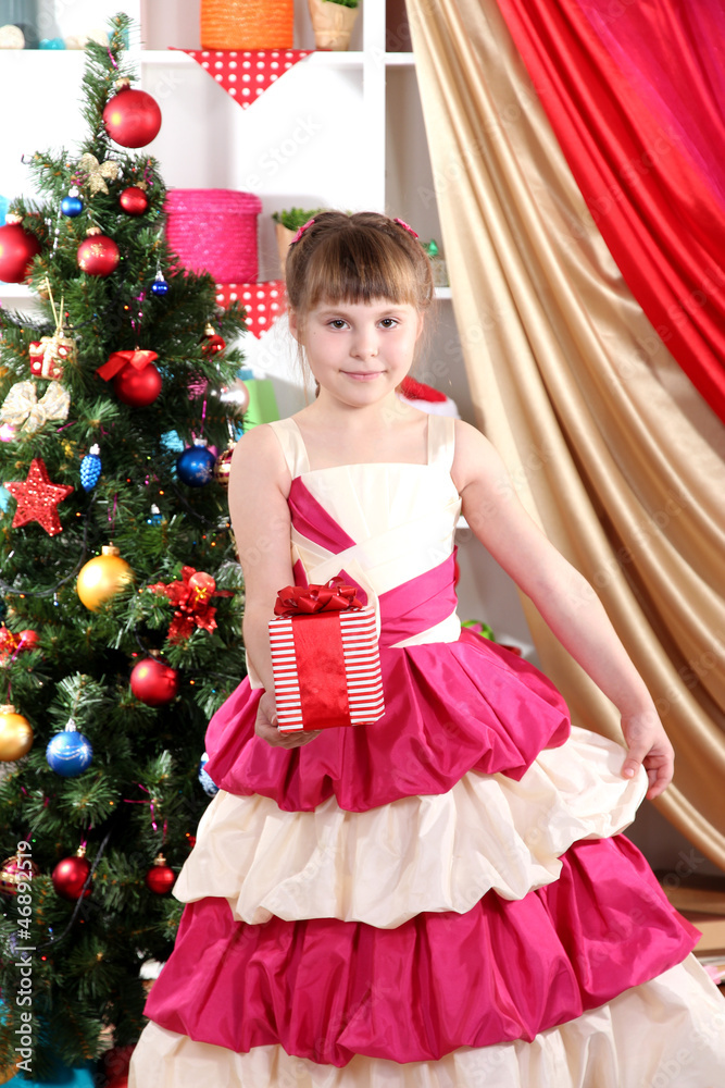 Beautiful little girl in holiday dress with gift in their hands Beautiful little girl in holiday dress with gift in their hands