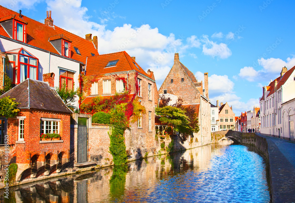 Fototapeta premium Beautiful view of a canal and , bridge, red roofs in Bruges, Bel