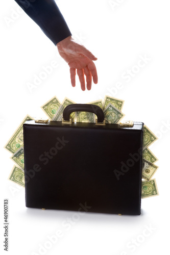 businessman reaching for a briefcase full of money