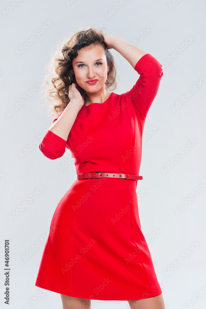 Portrait of a beautiful girl in a red dress on a gray background Portrait of a beautiful girl in a red dress on a gray background