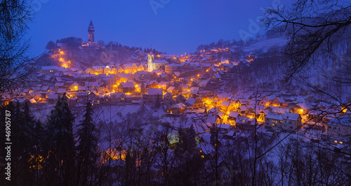 Tableau sur toile Snowy evening view of the lighted town