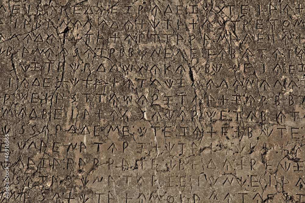 A Greek inscription carved in stone at ancient ruins A Greek inscription carved in stone at ancient ruins