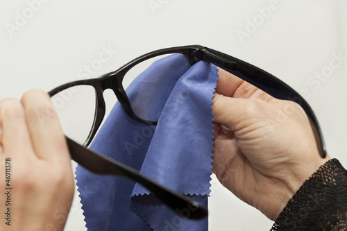 Woman trying to clean spectacles