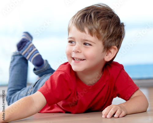 Three years old boy having fun on the floor